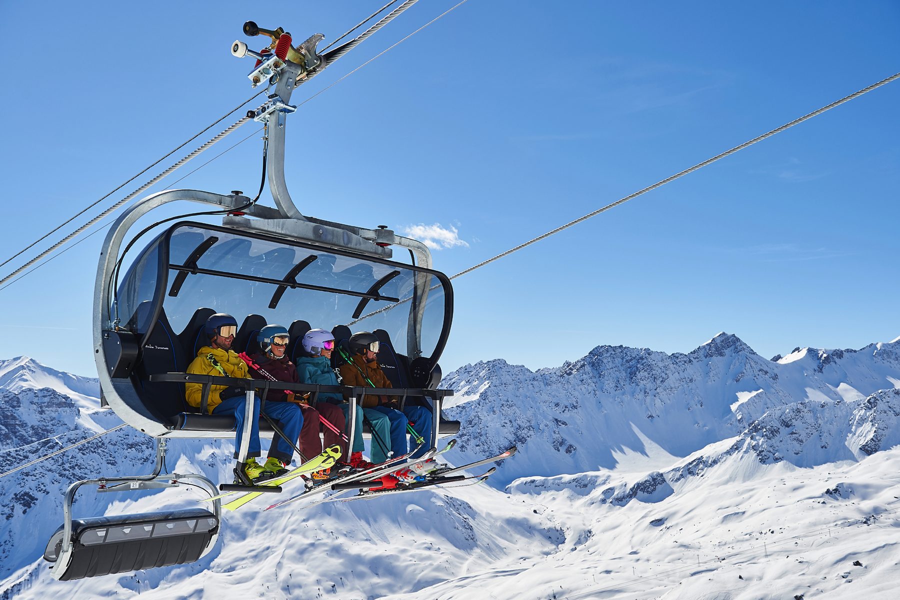 Skifahrende im Sessellift über der verschneiten Piste